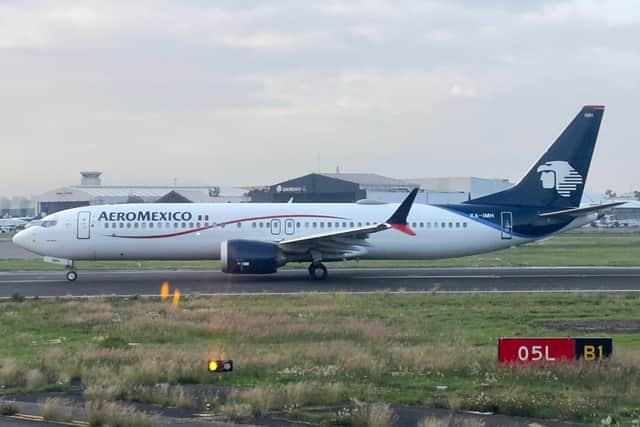 A passenger on board a grounded AeroMexico plane opens the emergency door and walks on wing after lengthy delay. (Photo: AFP via Getty Images)
