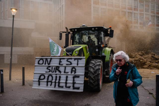 A tractor bearing the slogan 'We are on the straw' (a French expression signifying being financially ruined) dumps waste and manure outside a government administrative building in central Toulouse (Photo: ED JONES/AFP via Getty Images)