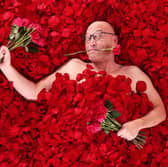 Gregg Wallace lies back in a bed of rose petals ahead of spreading the love the Valentine's Day - by giving red roses away for free Picture: PinPep / SWNS