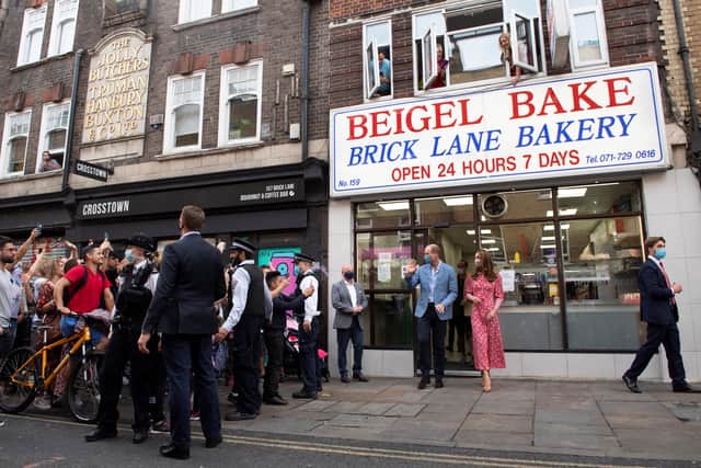 People watch from the windows above Beigel Bake Brick Lane Bakery as Prince William, Duke of Cambridge and Catherine, Duchess of Cambridge leave after visiting the bakery on September 15, 2020 in London, England. (Getty)
