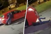 A woman was arrested after two people were injured after a car reversed at a crowd of people and flipped onto its roof - narrowly avoiding a man's head outside a pub in Birmingham. Picture: SWNS