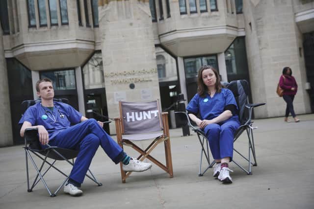Dr Rachel Clarke and Dr Dagan Lonsdale sit in chairs as they stage a 'peaceful protest' outside the Department of Health on April 13, 2016 