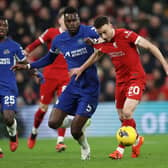 Diogo Jota of Liverpool runs in to score his team's first goal whilst under pressure from Benoit Badiashile of Chelsea  during the Premier League match between Liverpool FC and Chelsea FC at Anfield on January 31, 2024 in Liverpool, England. (Photo by Clive Brunskill/Getty Images)
