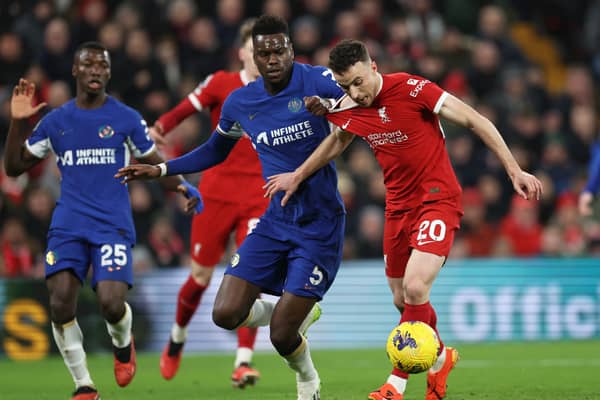Diogo Jota of Liverpool runs in to score his team's first goal whilst under pressure from Benoit Badiashile of Chelsea  during the Premier League match between Liverpool FC and Chelsea FC at Anfield on January 31, 2024 in Liverpool, England. (Photo by Clive Brunskill/Getty Images)