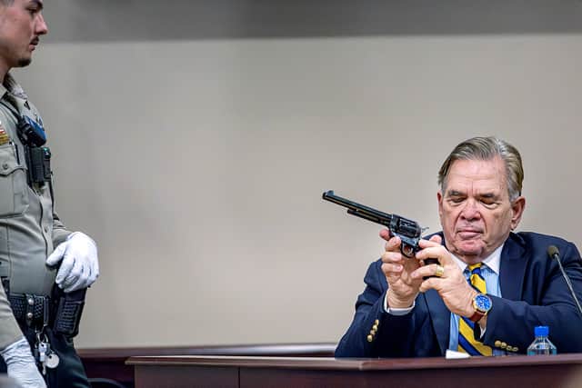 As Santa Fe County Deputy Levi Abeyta (L) watches, Expert witness for the defense Frank Koucky III demonstrates how to uncock a gun like the one used in the "Rust" shooting during testimony in Hannah Gutierrez-Reed's involuntary manslaughter trial at the First Judicial District Courthouse on March 5, 2024 in Santa Fe, New Mexico.Gutierrez-Reed, who was working as the armorer on the movie "Rust" when a revolver actor Alec Baldwin was holding fired killing cinematographer Halyna Hutchins and wounded the film's director Joel Souza, is charged with involuntary manslaughter and tampering with evidence. (Photo by Jim Weber - Pool/Getty Images)