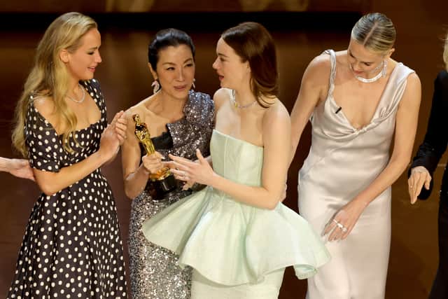 Emma Stone (2nd R) accepts the Best Actress in a Leading Role award for "Poor Things" from Jennifer Lawrence, Michelle Yeoh, and Charlize Theron onstage during the 96th Annual Academy Awards at Dolby Theatre on March 10, 2024 in Hollywood, California. (Photo by Kevin Winter/Getty Images)
