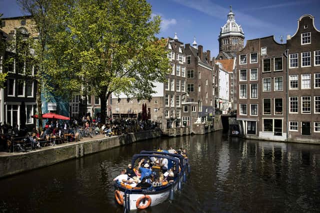 A tour boat is pictured on Damrak  downtown Amsterdam city, Netherlands, on April 16, 2022, during the Easter week. - Netherlands OUT (Photo by Ramon van Flymen /