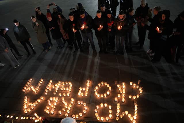 People lay flowers and lit candles in memory of the Moscow concert gun attack victims in the center of Simferopol, Crimea, on March 22, 2024. Gunmen opened fire at a Moscow concert hall on March 22, 2024 killing at least 40 people, wounding more than 100 and sparking an inferno, authorities said, with the Islamic State group claiming responsibility. (Photo by STRINGER / AFP) 