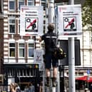 A municipal worker hangs a prohibition sign in the Nieuwmarkt publicising the new legislation forbidding the smoking of cannabis in public in the old city centre of Amsterdam on May 23, 2023. (Photo by Ramon van Flymen / ANP / AFP) 