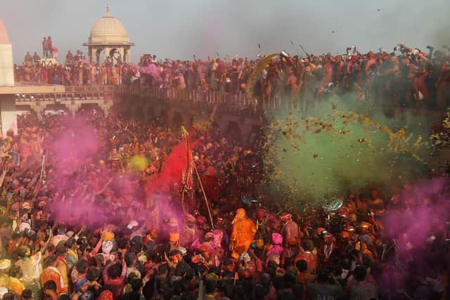 Revellers daubed in colours take part in Lathmar Holi celebrations, the Hindu spring festival of colours, at Nandgaon in India's Uttar Pradesh state on March 19, 2024. (Photo by AFP)