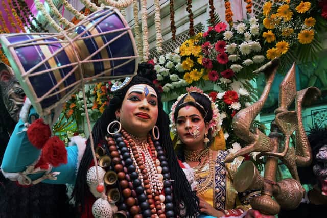 Devotees dressed as Hindu god Shiva and goddess Parvati take part in a religious procession  during Holi festival celebrations in Amritsar on March 20, 2024. (Photo by Narinder NANU / AFP)