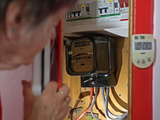 An energy customer examines their electricity meter (Photo: SUSANNAH IRELAND/AFP via Getty Images)