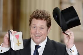 British actor and singer Michael Ball, poses for a photograph with his Officer of the Order of the British Empire (OBE) medal, after being presented with it during an investiture ceremony at Buckingham Palace in London on January 29, 2016.