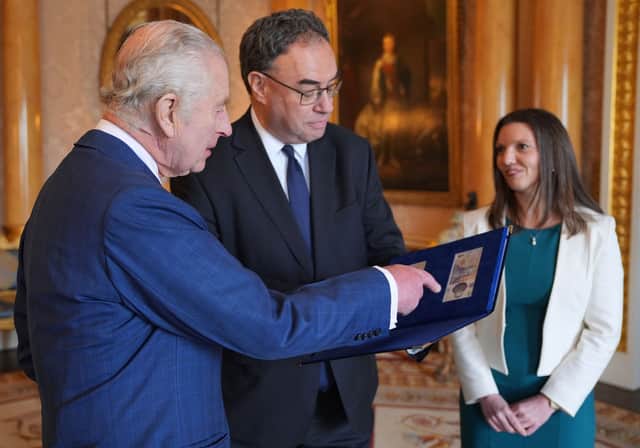 Britain's King Charles III with the Bank of England Governor Andrew Bailey (C) and Bank of England's Chief Cashier Sarah John who are presenting him with the first bank notes featuring his portrait, at Buckingham Palace in London on April 9, 2024