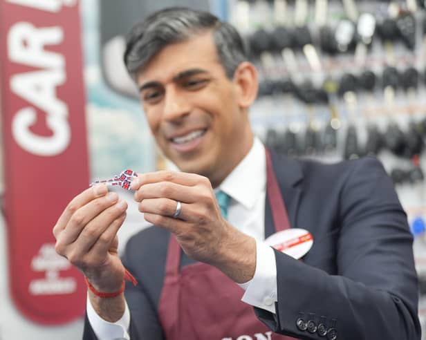 Prime Minister Rishi Sunak looks at a key after operating a cylinder key machine to copy and cut a cylinder key during a visit to a branch of Timpson, in central London after he gave a major policy speech on welfare reform where he called for an end to the "sick note culture". Credit: PA