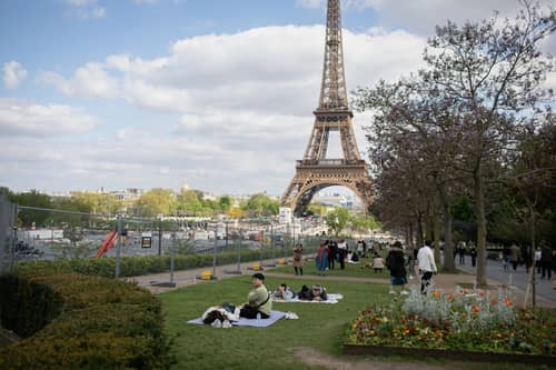 As you can see from the tourists picnicking next to the barrier where the ephemeral stadium will be erected for the  upcoming Olympics, experiencing France's food culture is important to visitors (Photo: Hans Lucas/AFP via Getty Images)