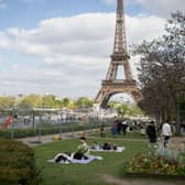 As you can see from the tourists picnicking next to the barrier where the ephemeral stadium will be erected for the  upcoming Olympics, experiencing France's food culture is important to visitors (Photo: Hans Lucas/AFP via Getty Images)