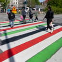 TOPSHOT - People walk across a zebra crossing at Mollevangstorget square painted in the Palestinian colours in Malmo, Sweden, in protest against Israel's participation in the 68th edition of the Eurovision Song Contest (ESC) on May 9, 2024. (Photo by Johan NILSSON / TT NEWS AGENCY / AFP)