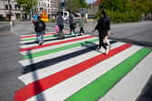TOPSHOT - People walk across a zebra crossing at Mollevangstorget square painted in the Palestinian colours in Malmo, Sweden, in protest against Israel's participation in the 68th edition of the Eurovision Song Contest (ESC) on May 9, 2024. (Photo by Johan NILSSON / TT NEWS AGENCY / AFP)