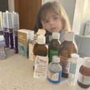 Harlow, six, with various medications she has needed for her skeletal dysplasia