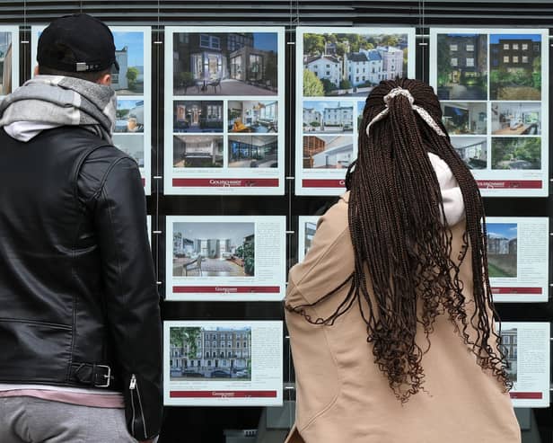 People look at residential properties displayed for sale in the window of an estate agent (Photo: ISABEL INFANTES/AFP via Getty Images)
