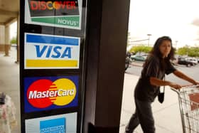 A shopper passes a shop door advertising acceptance of purchases with Master Card, Visa and other credit cards (Photo: David McNew/Getty Images)