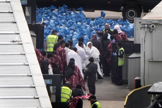 A group of people believed to be migrants are lead through the Border Force compound in Dover, Kent, following a number of small boat crossings in the Channel yesterday.