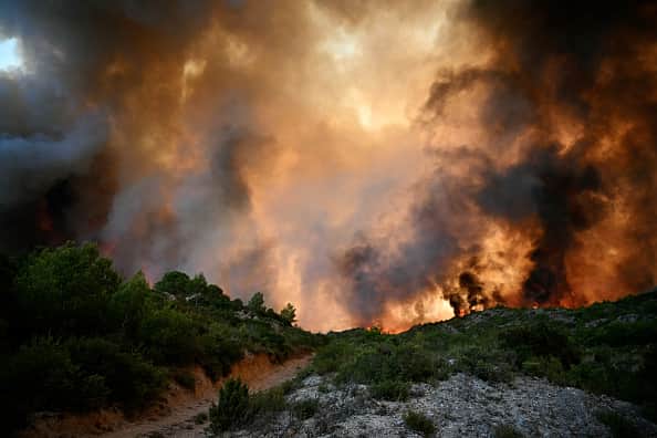 TOPSHOT - A forest is engulfed in flames as a wildfire rages near Fontjoncouse, southwestern France, on August 6, 2025. A wildfire has killed one person and injured nine others, scorching 11,000 hectares as firefighters work to contain the blaze, local officials said. The fire, which started the day before, has destroyed or damaged 25 homes in the southern Aude department, where more than 1,800 firefighters have been battling to control what is now the largest wildfire in France this summer. (Photo by Lionel BONAVENTURE / AFP) (Photo by LIONEL BONAVENTURE/AFP via Getty Images)