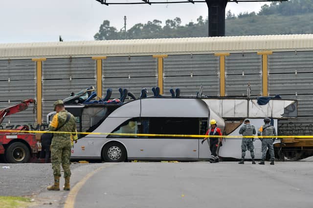 Military personnel stand guard after a fatal collision between a freight train and a passenger bus in Toluca, Mexico