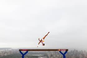 Thrill-seeking athlete Lily Smith has performed a daring balance beam routine 52 stories above street level.