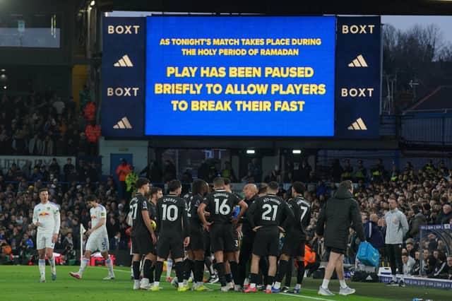 Players stand during a pause as observing Muslim players break the Ramadan fast during the Premier League soccer match between Leeds United and Manchester City