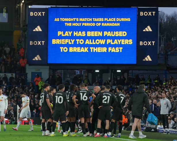 Players stand during a pause as observing Muslim players break the Ramadan fast during the Premier League soccer match between Leeds United and Manchester City