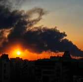 A plume of smoke rising after a military strike in Tehran, Iran