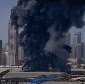 A black plume of smoke rises from a warehouse at the industrial area of Sharjah City in the United Arab Emirates 