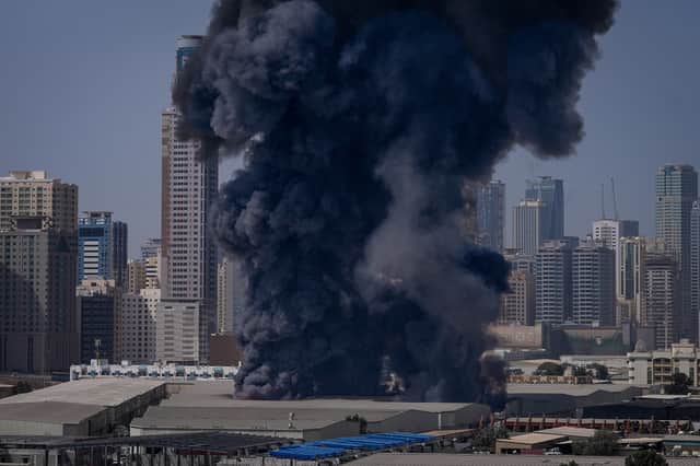 A black plume of smoke rises from a warehouse at the industrial area of Sharjah City in the United Arab Emirates