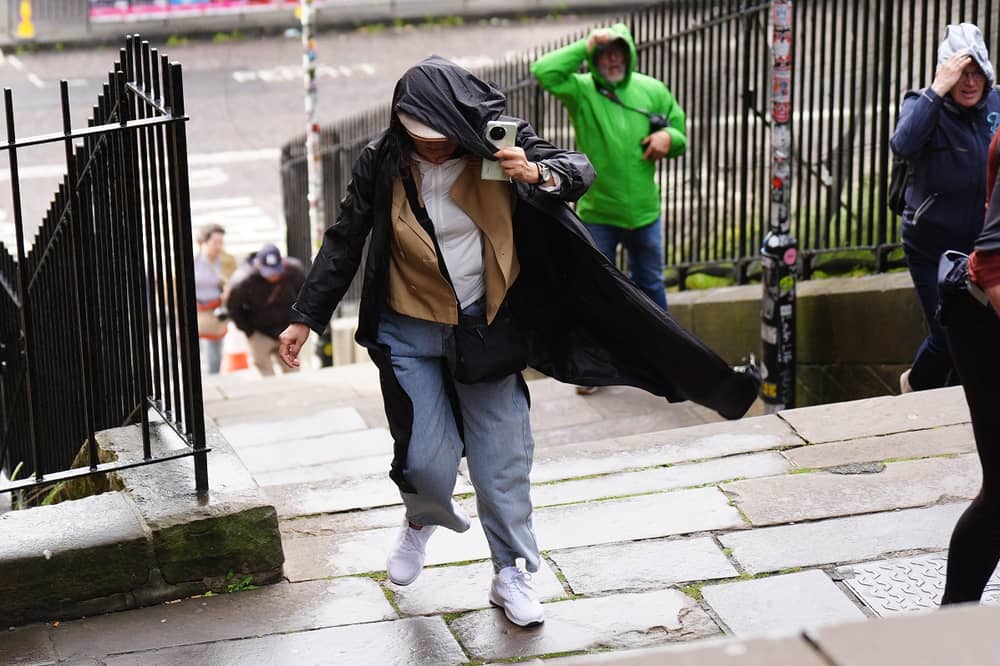 Members of the public battle against the wind as they walk along the Royal Mile, Edinburgh