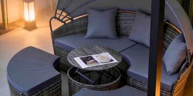 This rattan day bed set transforms into a cosy evening retreat with soft lighting and practical table space