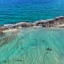 Are UK tourists staying away from Cyprus, what does the government’s Foreign travel advice state? This aerial picture shows swimmers at Ayia Thekla beach near the coastal tourist resort town of Ayia Napa on July 13, 2025. (Photo by Etienne TORBEY / AFP) (Photo by ETIENNE TORBEY/AFP via Getty Images)          