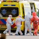 Medics escort a patient, second right, evacuated from the MV Hondius cruise ship with suspected hantavirus infection, to an ambulance after being flown to Schiphol airport, Amsterdam, Netherlands