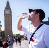 A man cools down with a bottle of water during the hot weather in Westminster Bridge, central London