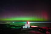 The aurora borealis, commonly known as the Northern Lights, light up the skies above Bamburgh lighthouse in Northumberland