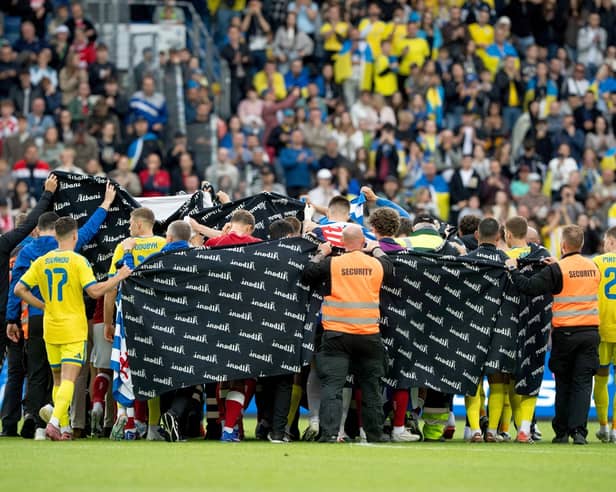 Denmark's and Ukraine's players accompany Christian Eriksen to a waiting ambulance during the international friendly soccer match between Denmark and Ukraine in Odense