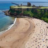 People enjoying the sun at King Edward's Bay, Tynemouth on the northeast coast of England