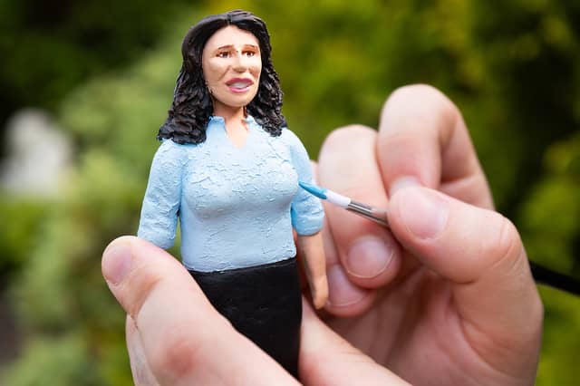 Model painter Reece Winters puts the finishing touches to the miniature Nigella Lawson.