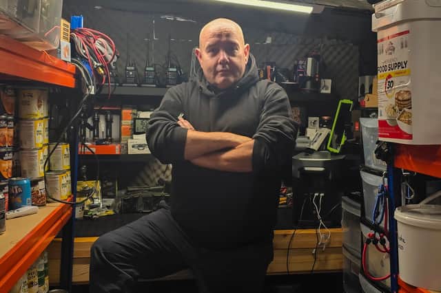 Disaster prepper *Brian Forbes' inside his shelter, stocked with supplies including tins of produce,
