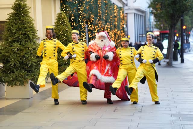 Santa Claus with Bellhops dressed in uniforms inspired by New York City taxis at the unveiling of Selfridges Christmas windows on Oxford Street