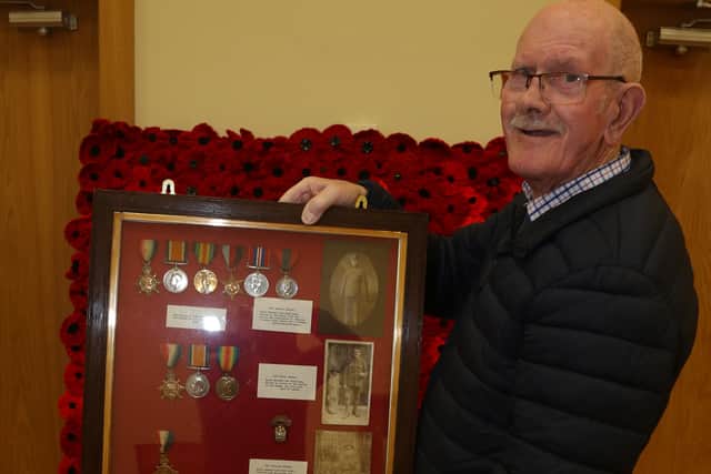 Jim Hunter, a church elder, displays a framed collage of photographs and medals donated by Newtownstewart native, Billy Dunbar. The photos and medals are of three uncles, Johnny, William and Thomas Dunbar, who lost their lives in WW1. Billy's father, Samuel, served in the two World Wars and was at the evacuation of Dunkirk, later became a postman around Newtownstewart. AN442626