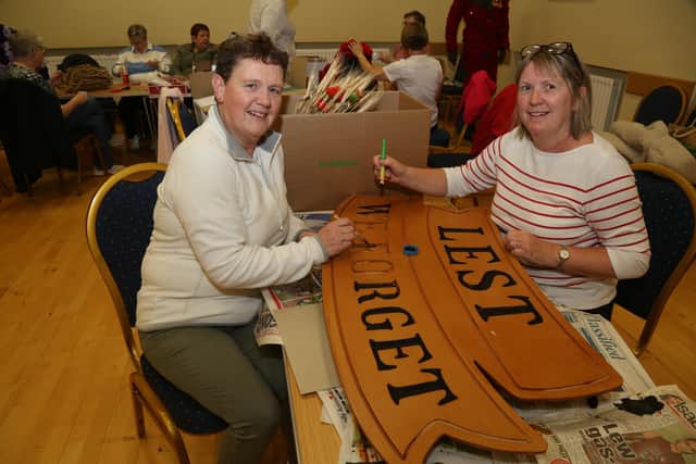 Sisters, Elaine Managh and Wilma Hughes put the finishing touches to a 'Lest We Forget' sign during the preparation for the Festival of Poppies. AN443126