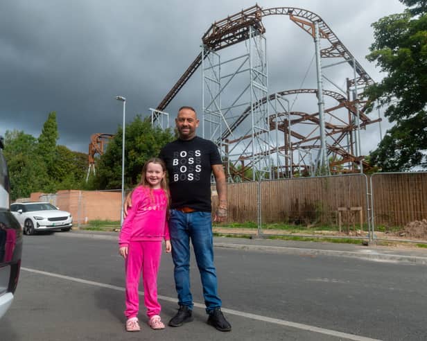 Jack Welsh and his daughter Sapphire Rose-Welsh, next to a rollercoaster built next to a housing estate in Hucknall, nr. Nottingham