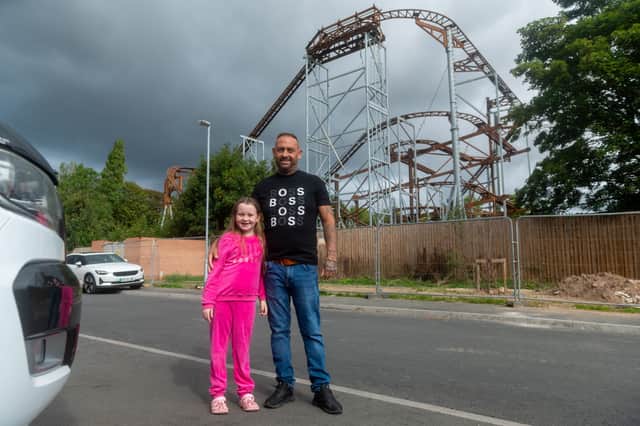 Jack Welsh and his daughter Sapphire Rose-Welsh, next to a rollercoaster built next to a housing estate in Hucknall, nr. Nottingham